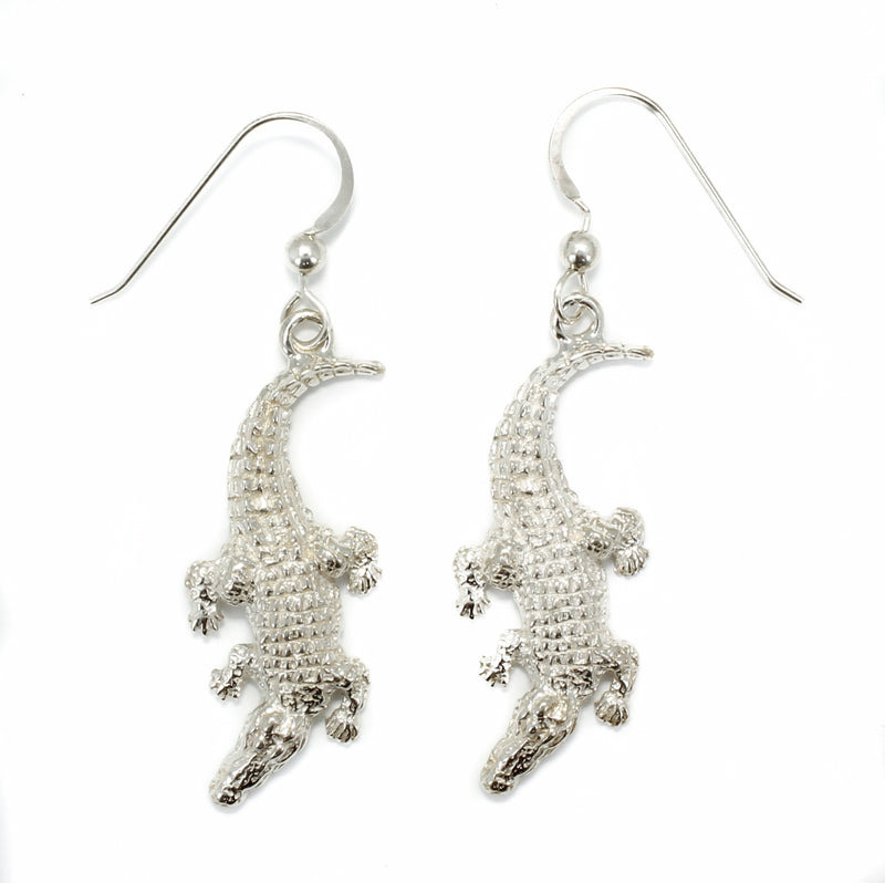 A pair of silver alligator earrings.