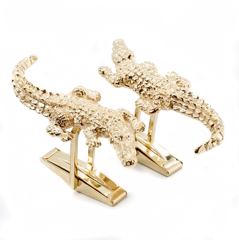 A pair of gold alligator cuff links.