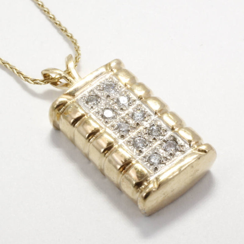 A gold cotton bale necklace with diamonds.