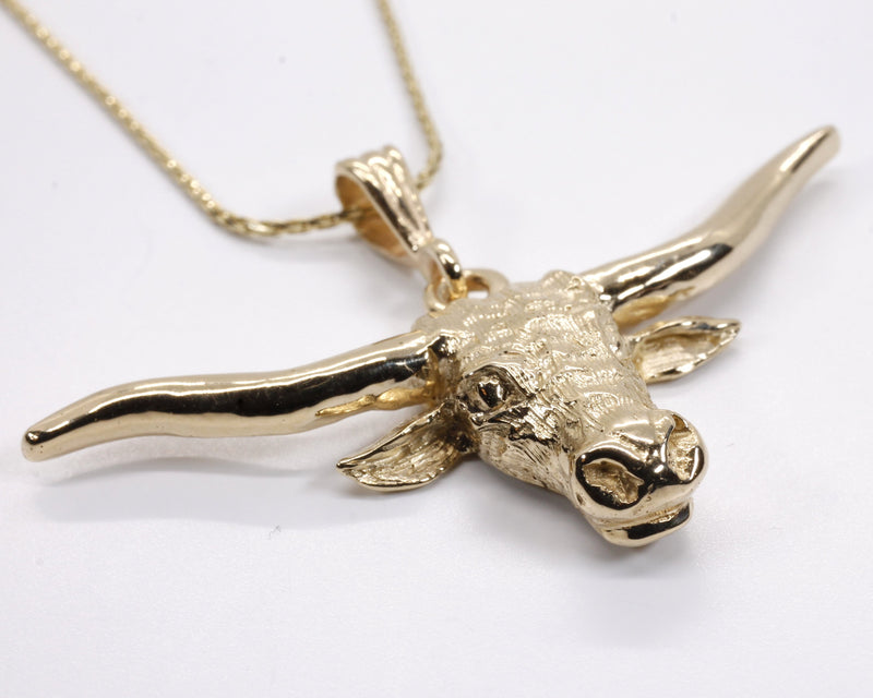A gold Texas Longhorn necklace and pendant.