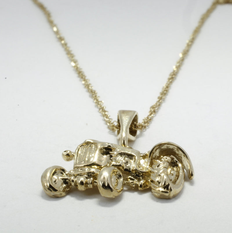 A gold necklace and tractor charm.